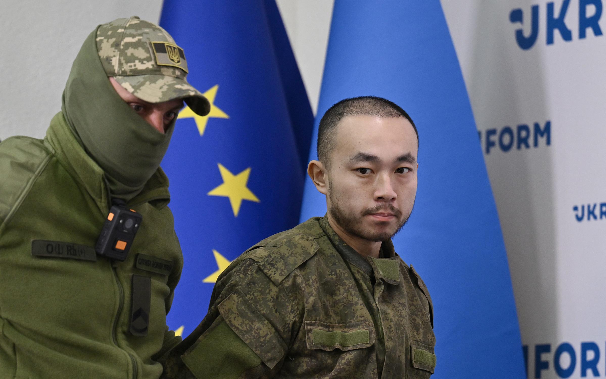 Zhang Renbao jest eskortowany przez Ukraińskiege strażnika.